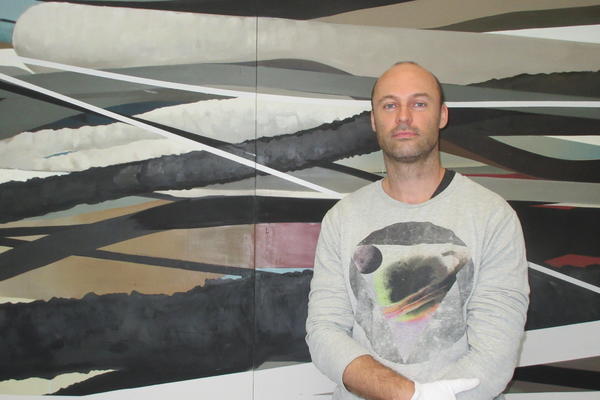 Sebastian Menzke w&auml;hrend des Ausstellungsaufbaus vor seinem vierteiligen Gem&auml;lde &raquo;again&laquo;                      