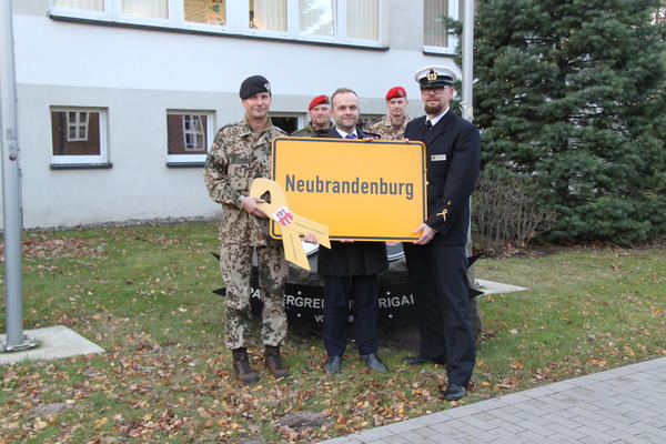 Oberst Michael Sack (links) bekam stellvertretend für alle Soldaten der Panzergrenadierbrigade 41 ein Ortseingangsschild von Neubrandenburg geschenkt