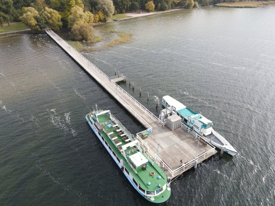 Eine Luftaufnahme des Badehausstegs des Neubrandenburger Tollensesees mit zwei angelegten Booten.