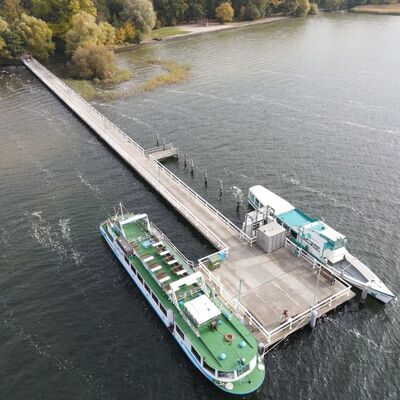 Eine Luftaufnahme des Badehausstegs des Neubrandenburger Tollensesees mit zwei angelegten Booten.